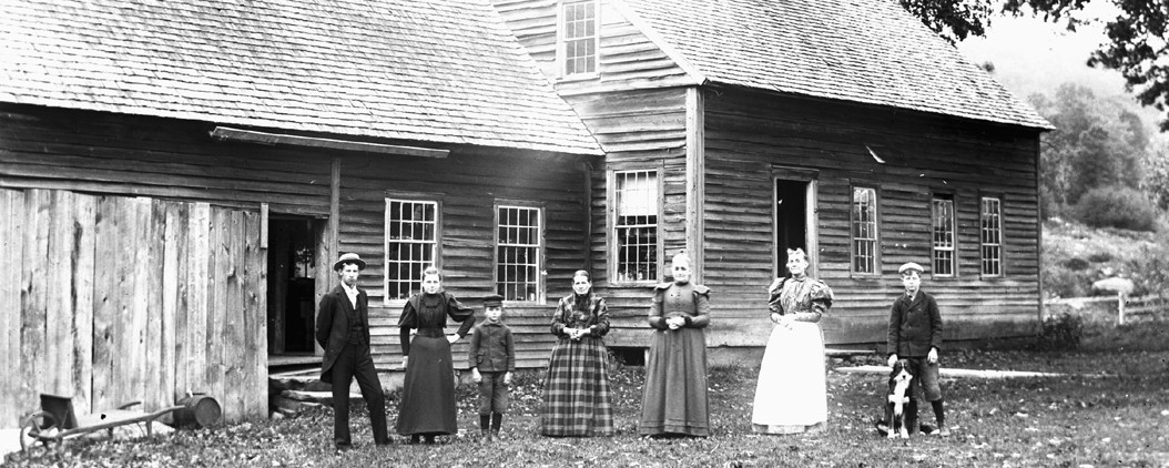 group of adults and children standing in front of a house