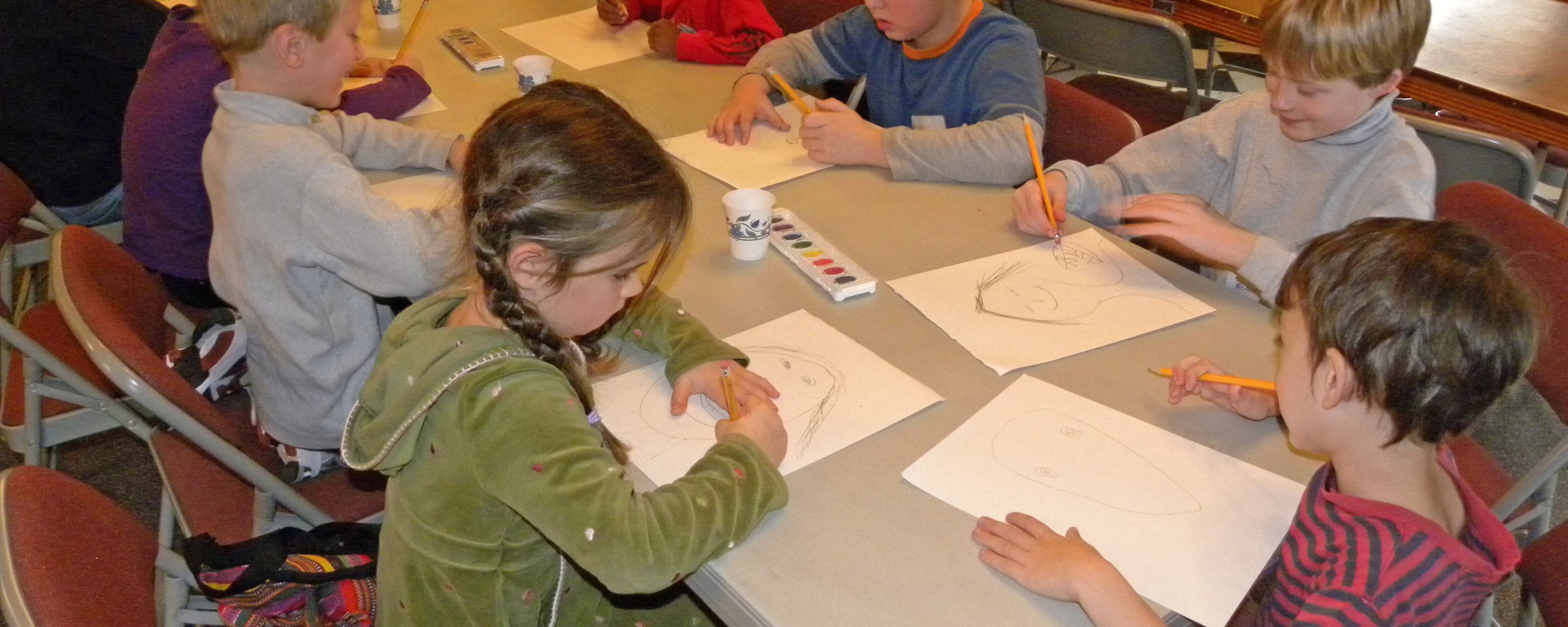 children drawing pictures at a table