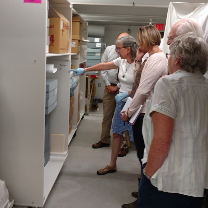 person showing museum storage to group of people