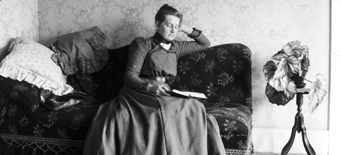 old photo of woman reading book on couch