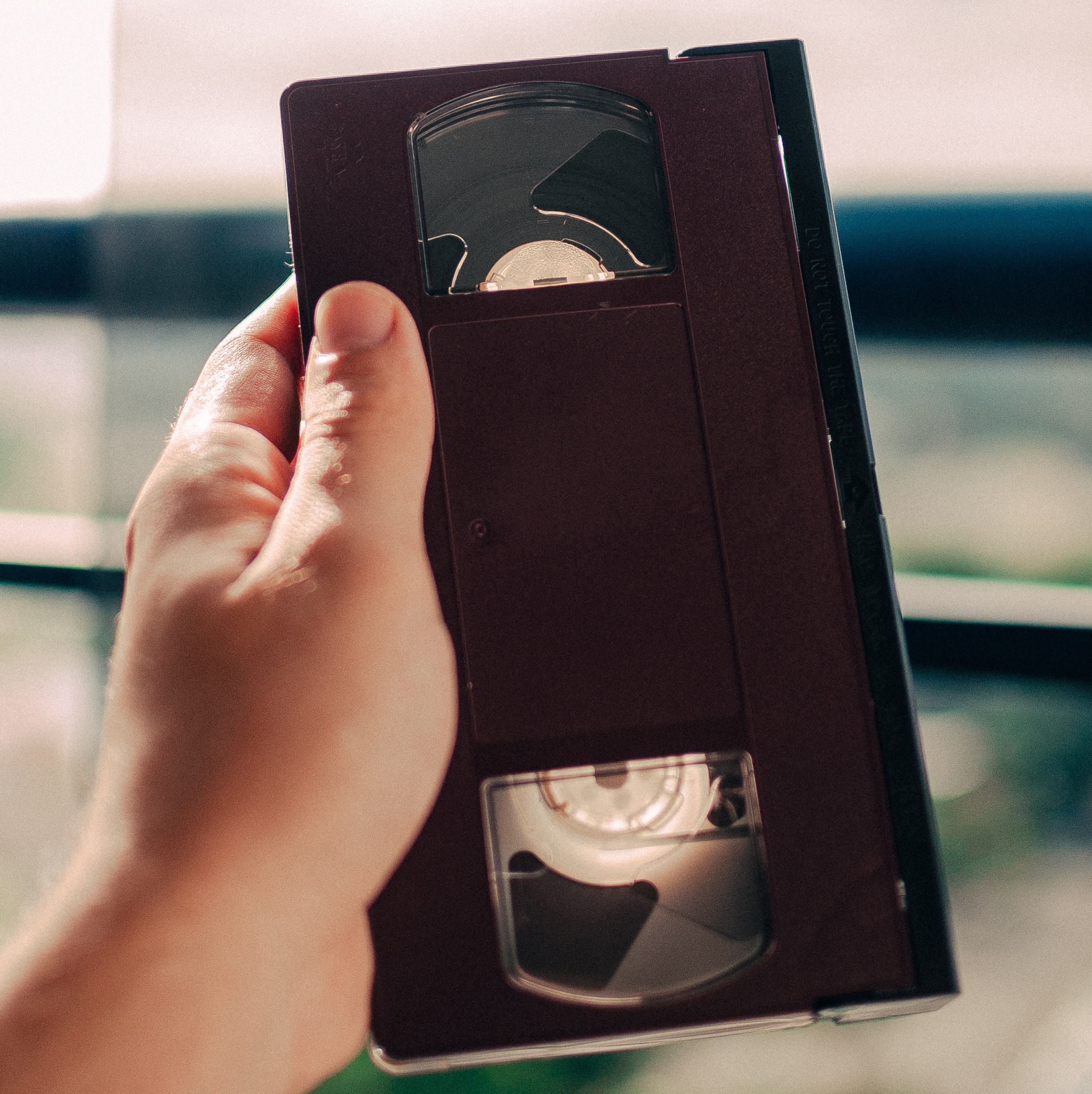 hand holding a VHS video cassette.