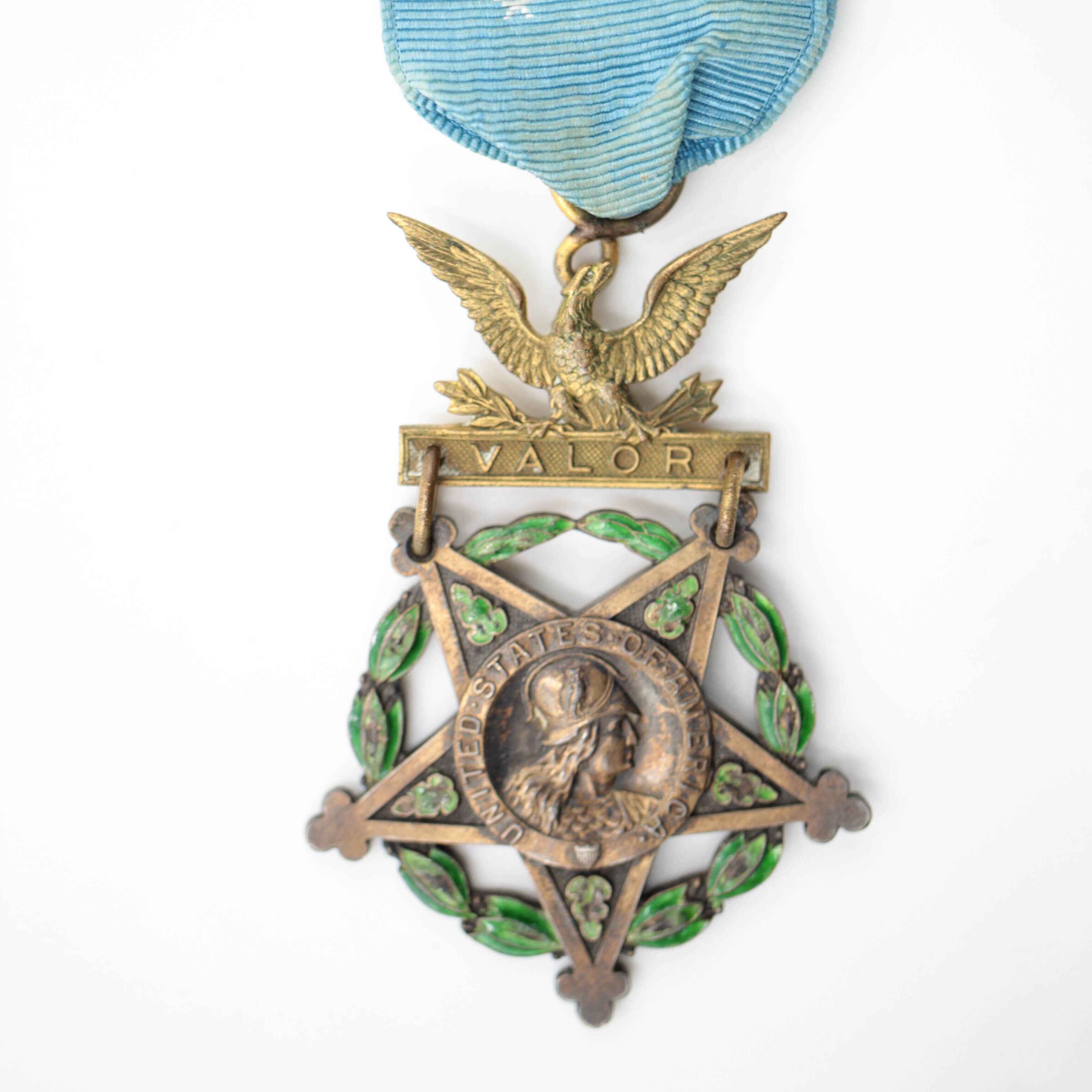 medal in shape of star with blue ribbon, eagle, and the word 