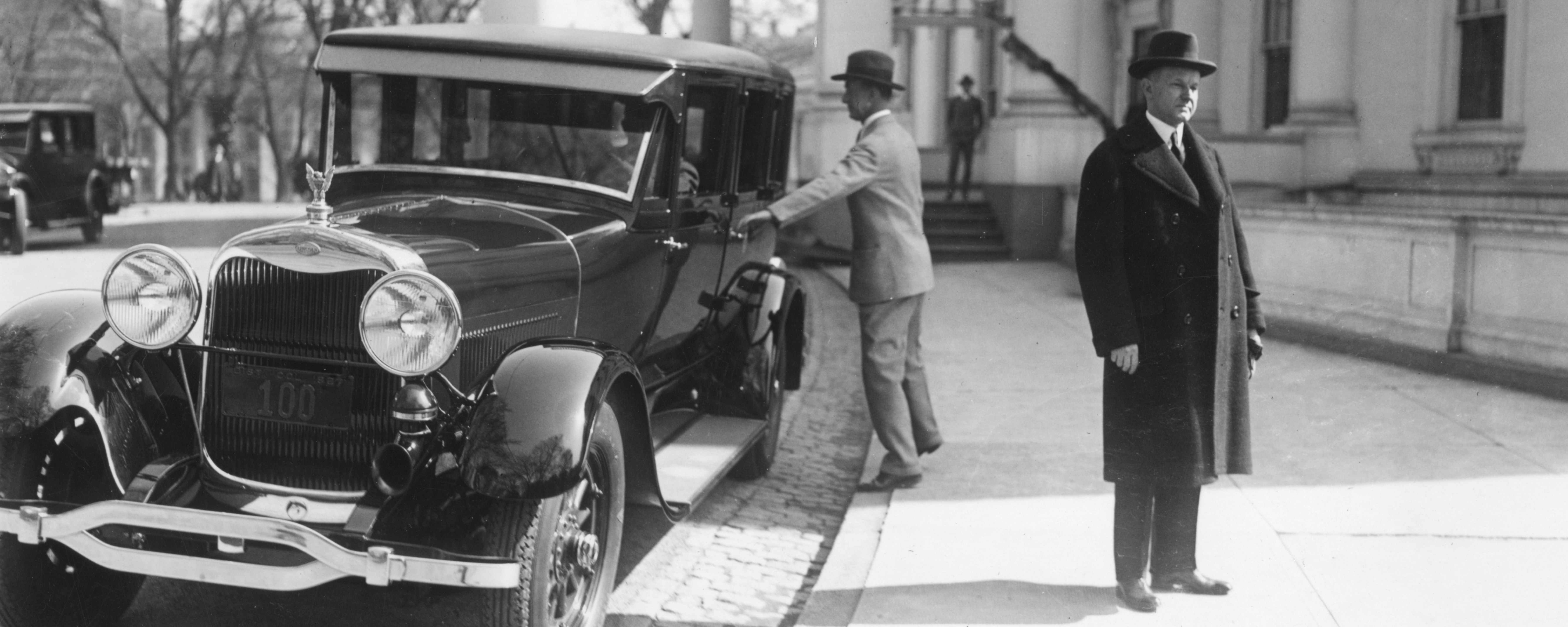 Calvin Coolidge standing by car