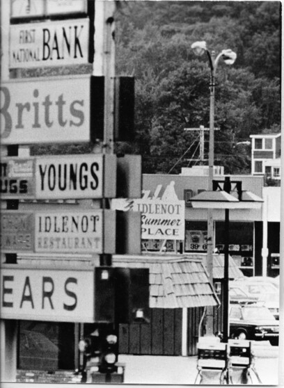 old photo of cluttered signs by road