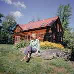 woman sitting on rock with building behind