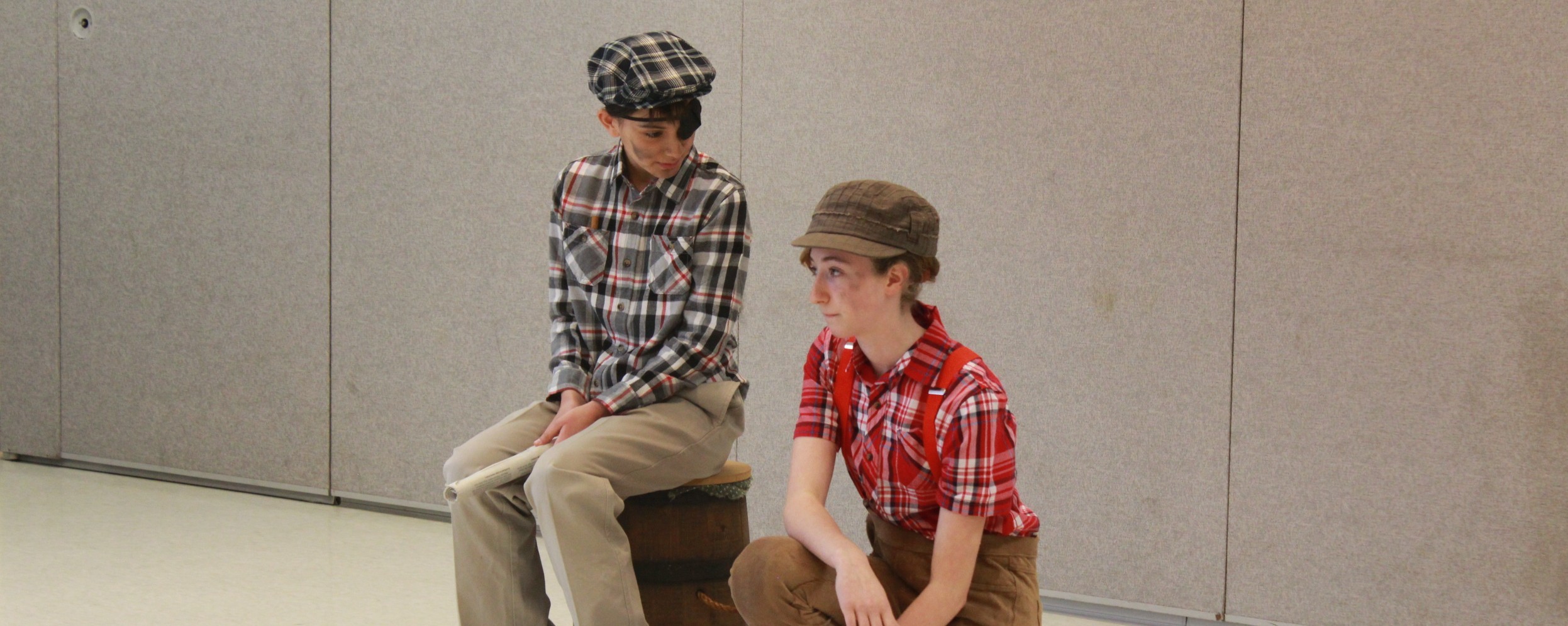 two students dressed as newspaper boys for performance